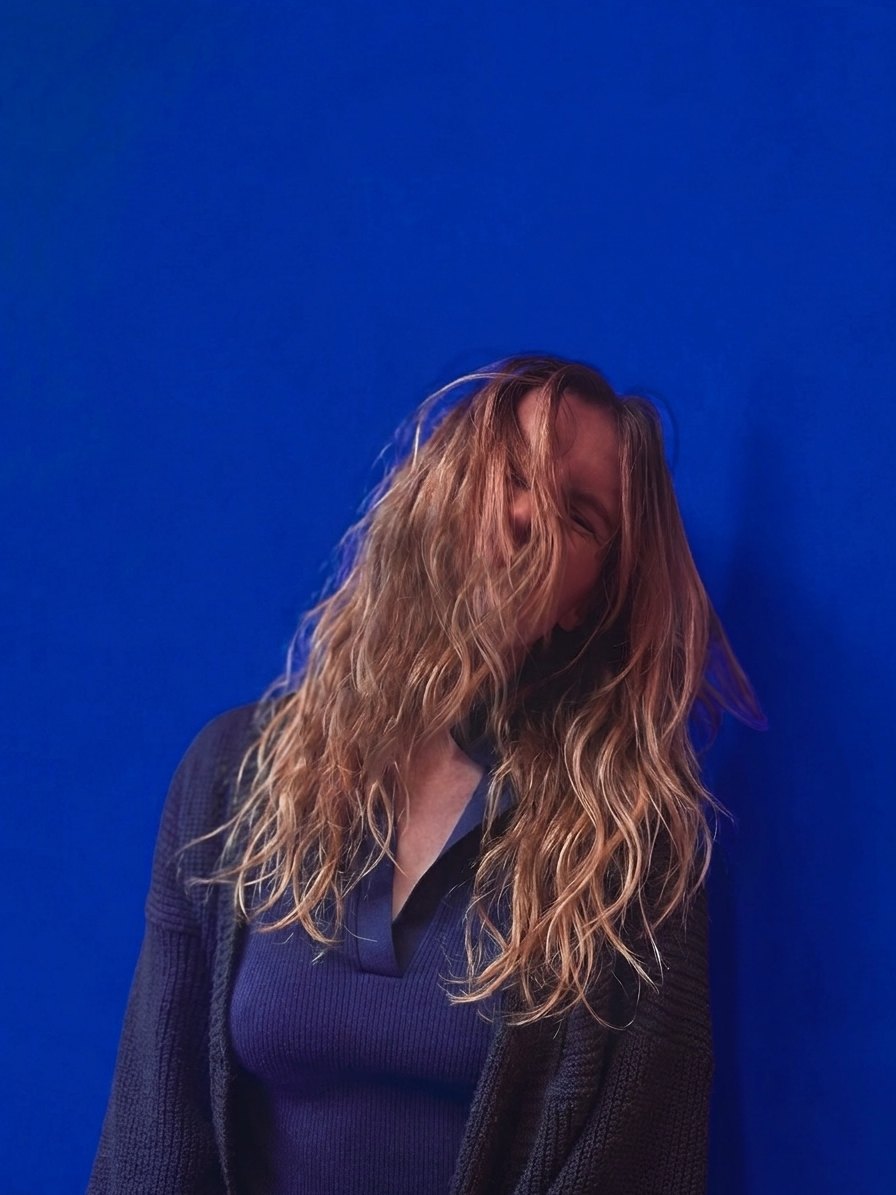 Olivia Andersson in front of a deep blue wall